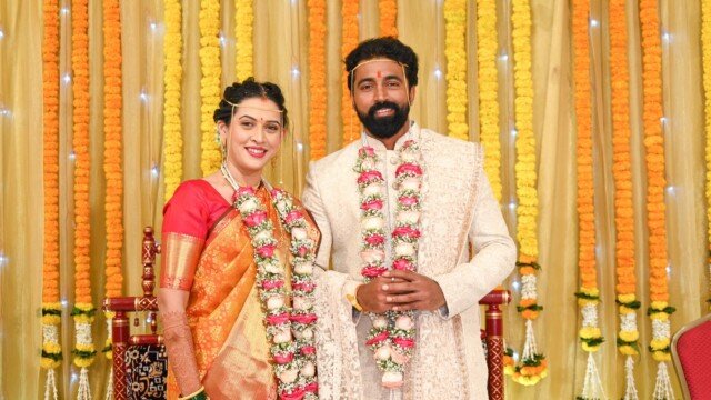 Married couple pose with Wedding Garlands